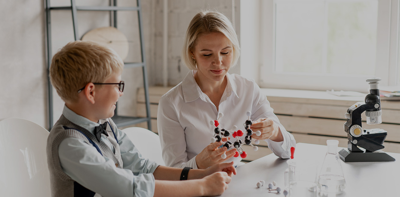 Female science tutor in Atlanta studying chemistry with student